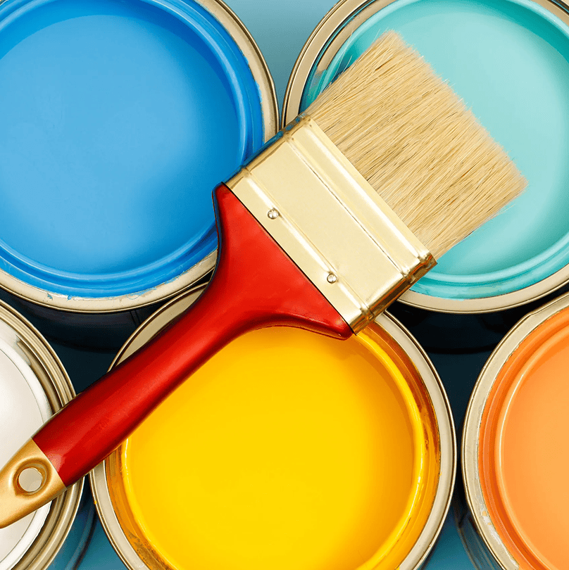 Paintbrush resting on vibrant paint colors