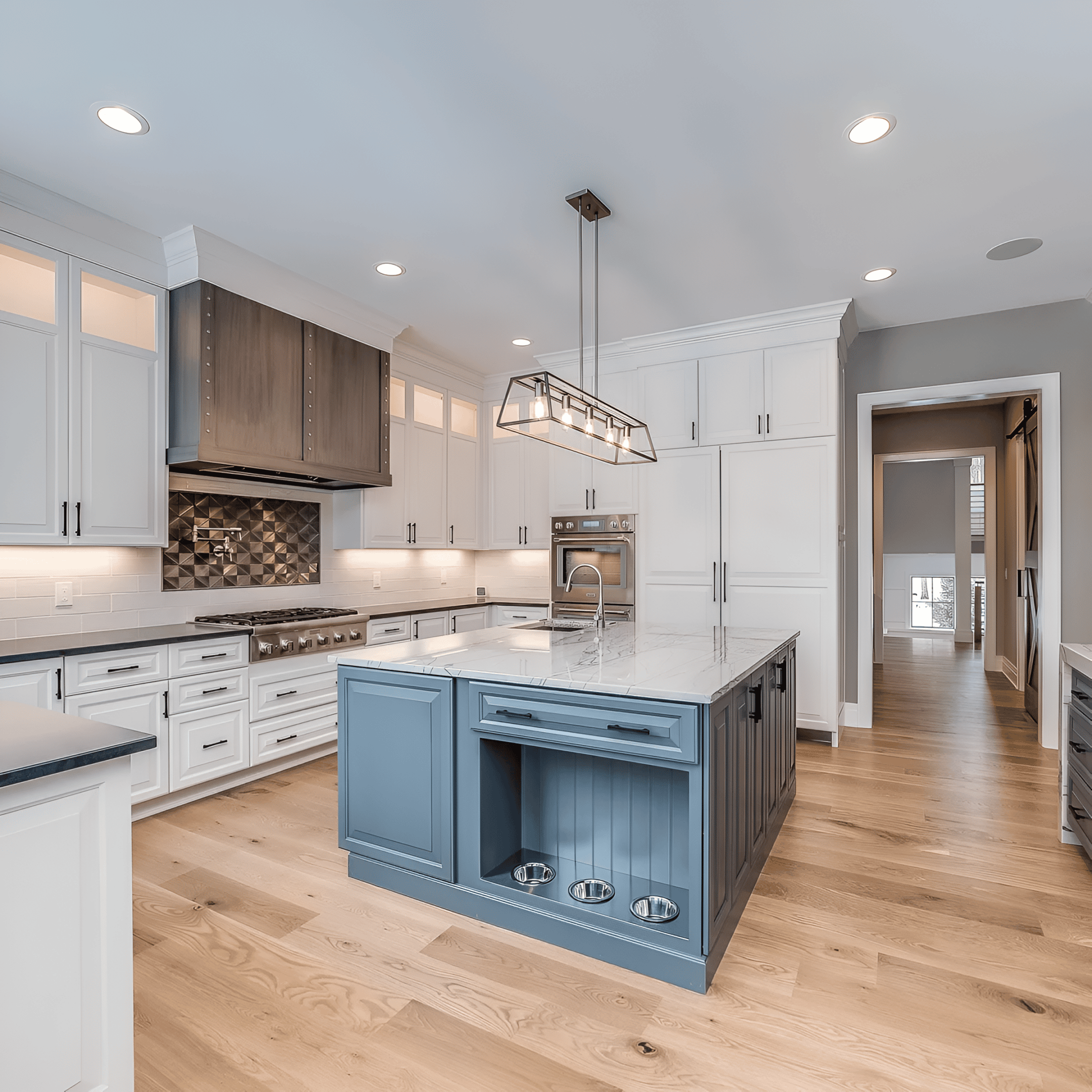 Modern kitchen with island and wood flooring.